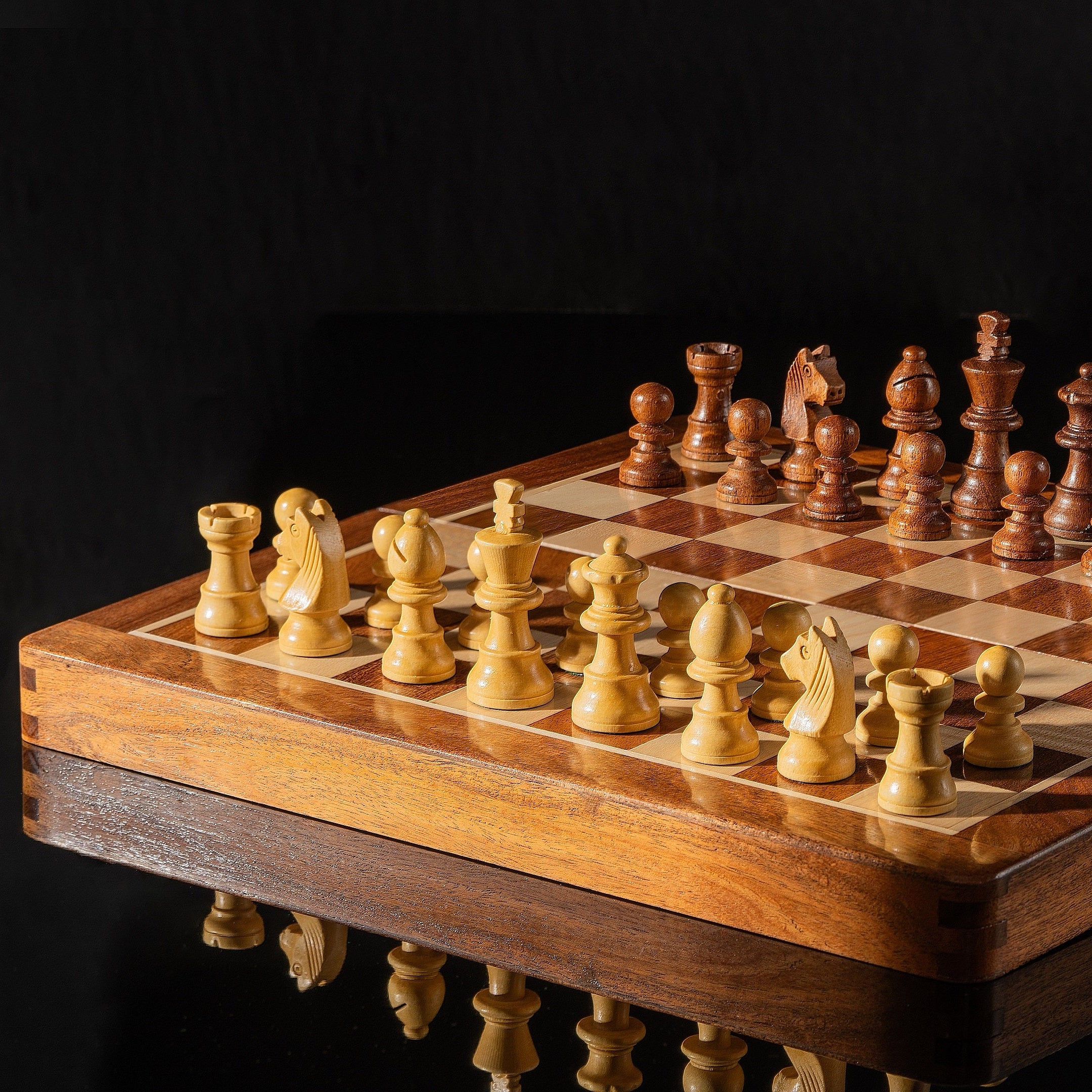 Aufgebautes Schachspiel mit Intarsien-Brett, dramatisch beleuchtete Nahaufnahme